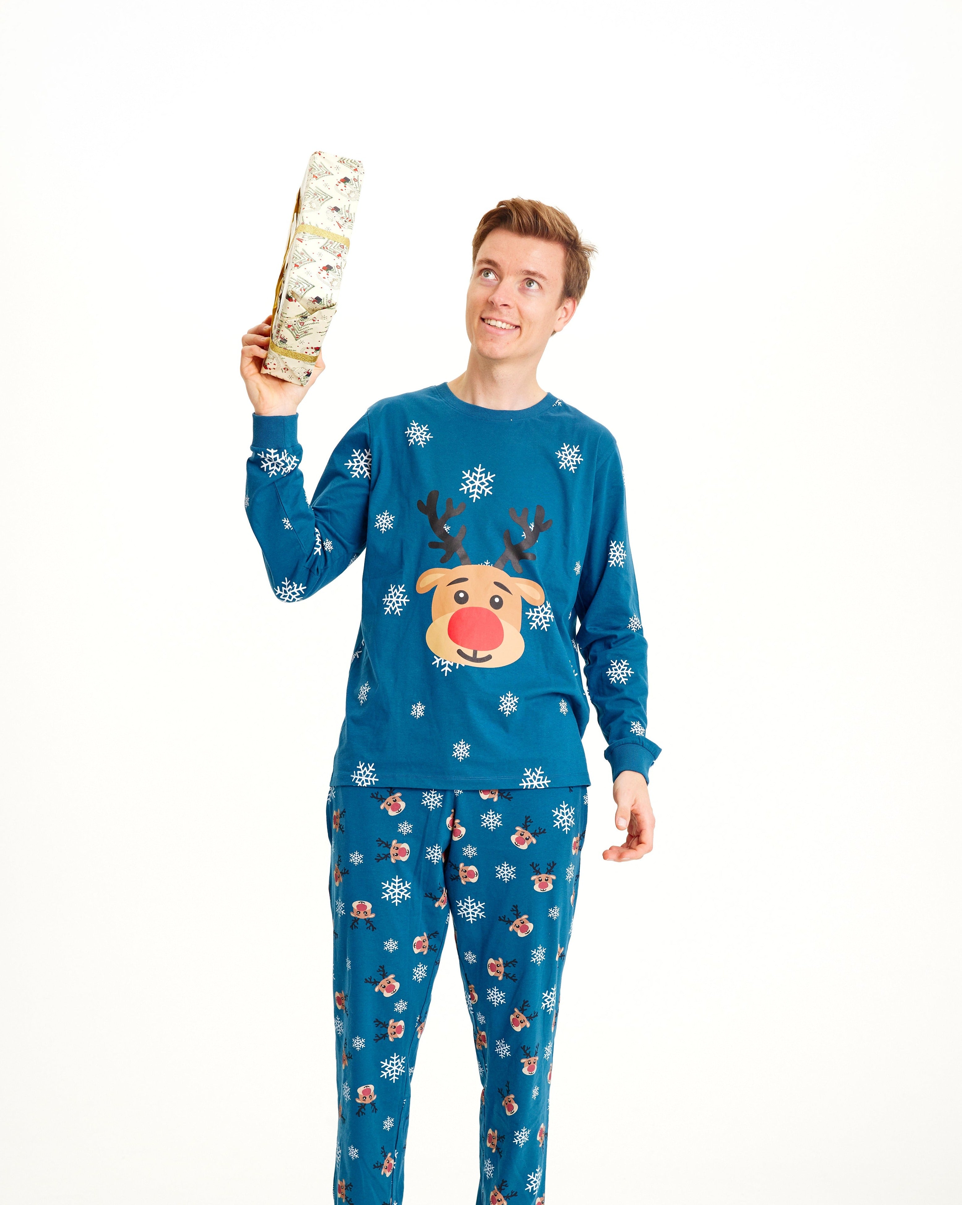 Een man in een blauwe kerstpyjama met Rudolph erop.